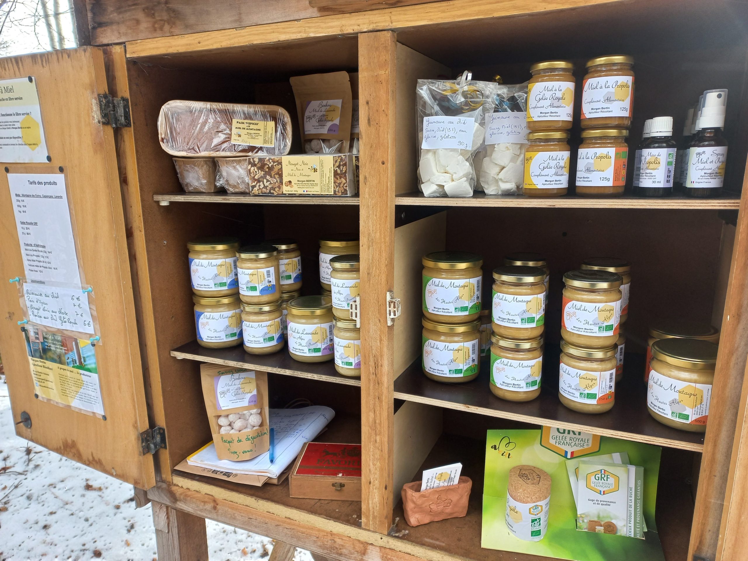 Produits de la ruche de Morgan Bertin présentés sur une étagère en bois